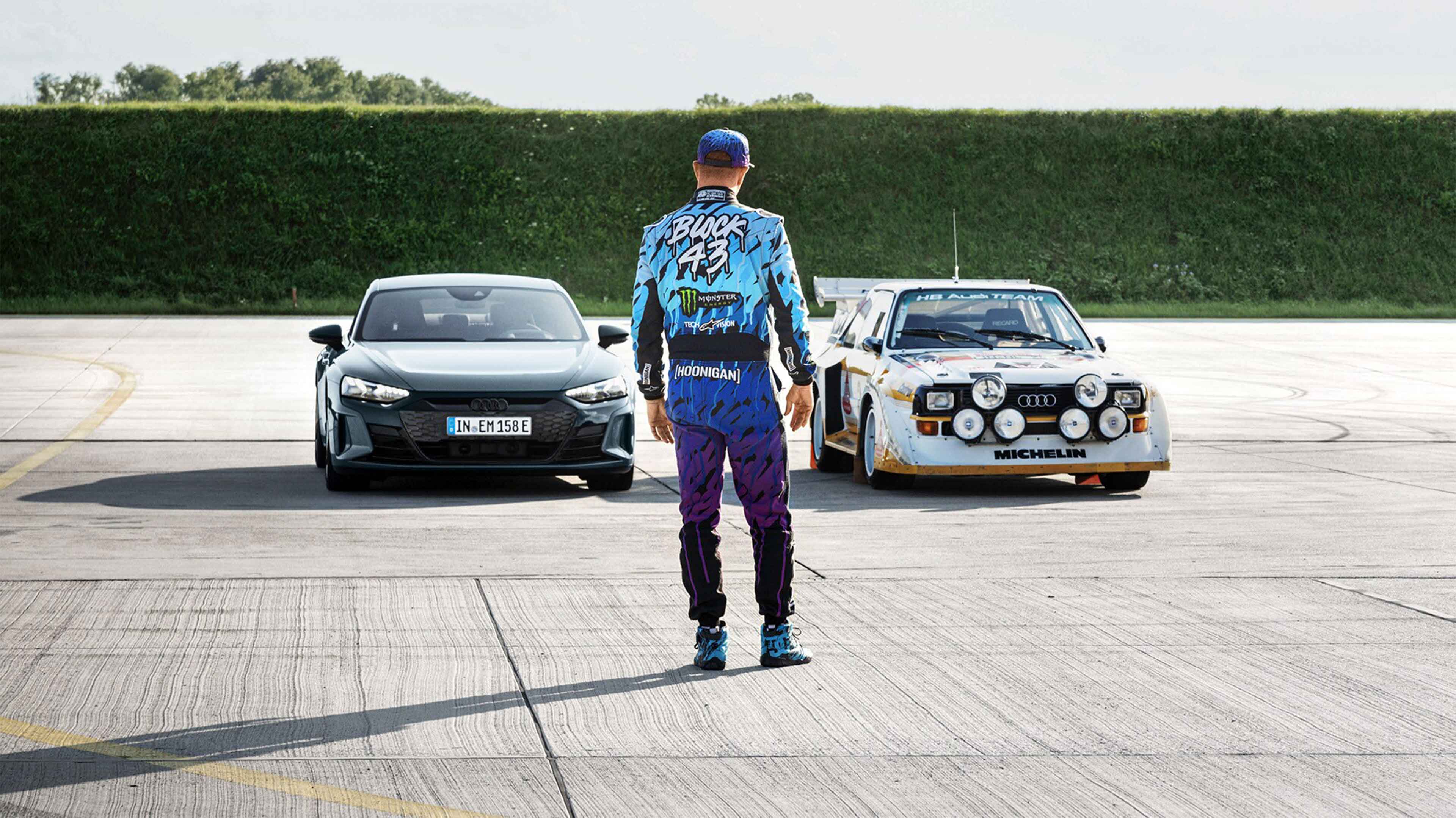 The legendary Audi quattro S1 E2と電気自動車Audi RS e-tron GTの前に立つケン・ブロック